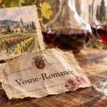 Étiquette vosne romanee sur table chêne, verre et vignoble
